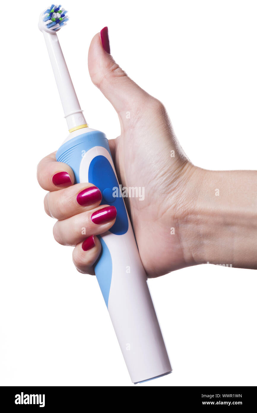 Hand holds electric toothbrush against white Stock Photo