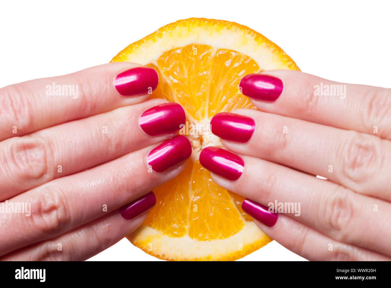 Hand with manicured nails touch an orange on white Stock Photo