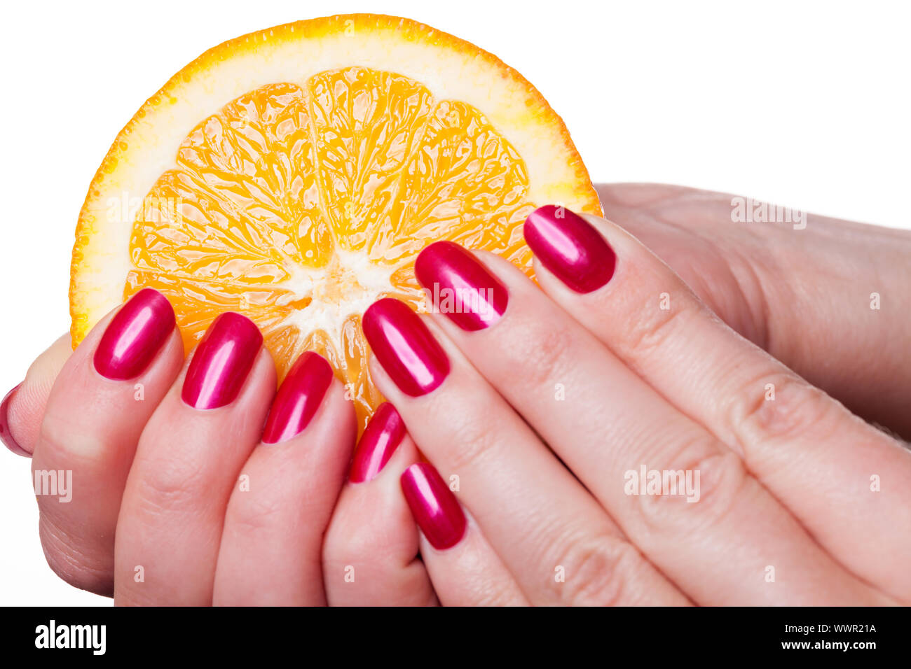 Hand with manicured nails touch an orange on white Stock Photo