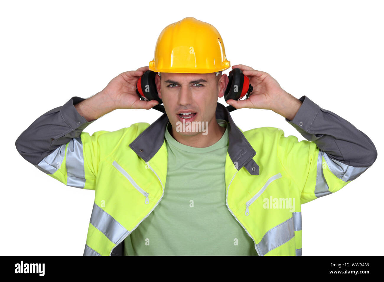 builder with hard hat removing earmuffs Stock Photo Alamy