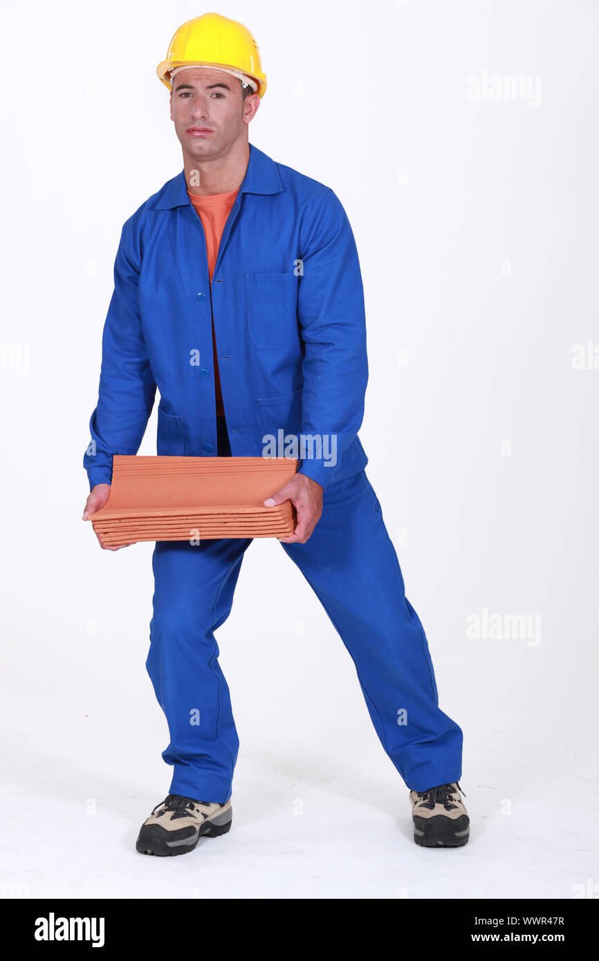 A roofer carrying tiles roof. Stock Photo