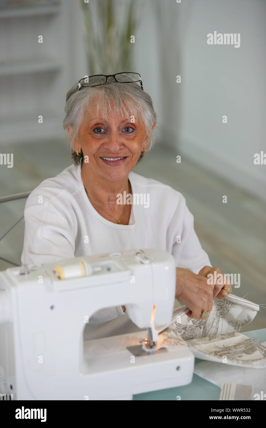 Elderly lady using sewing machine Stock Photo Alamy