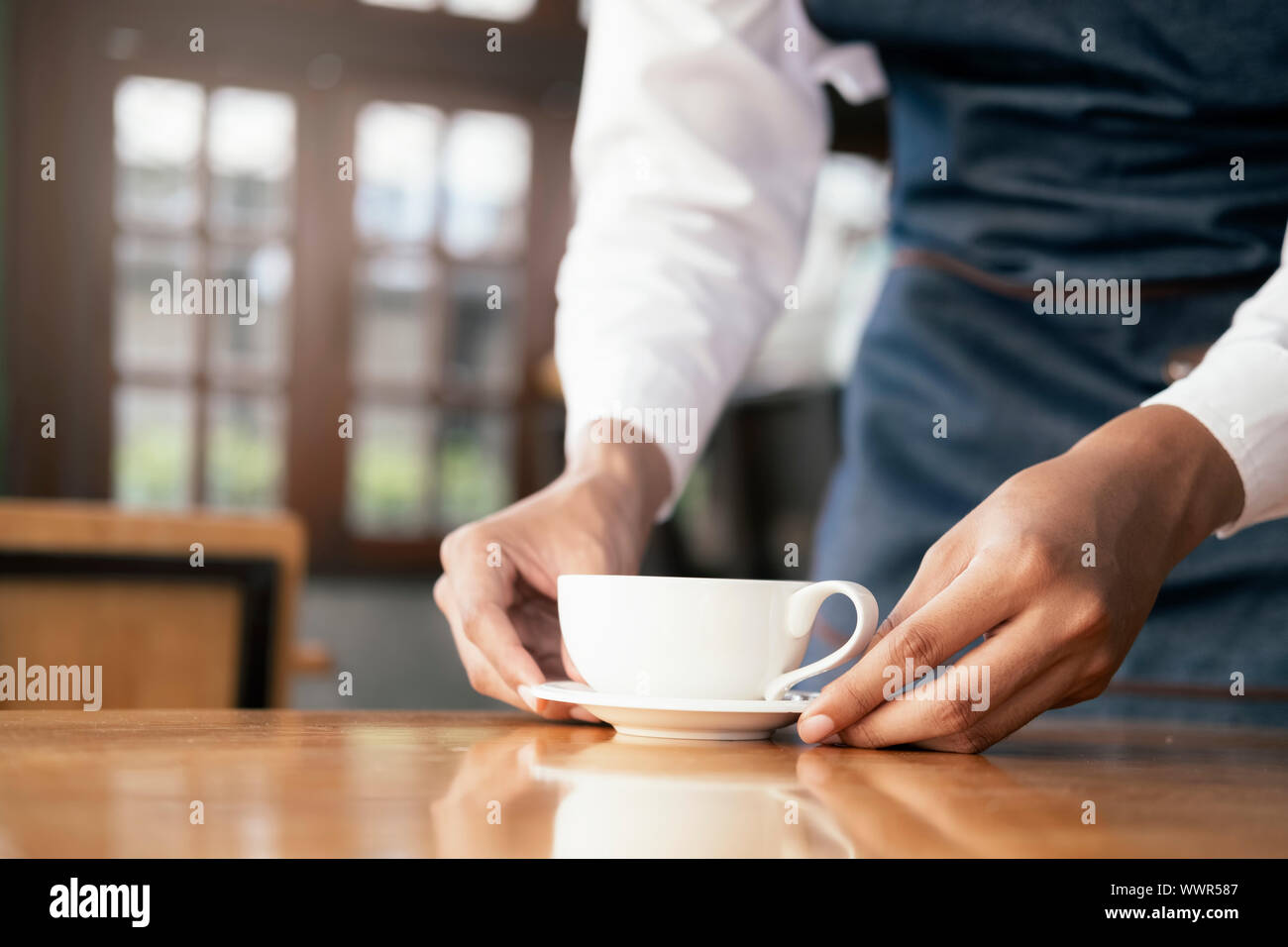 Young owner of coffee cafe service customer. Small business and owner business concept. Stock Photo