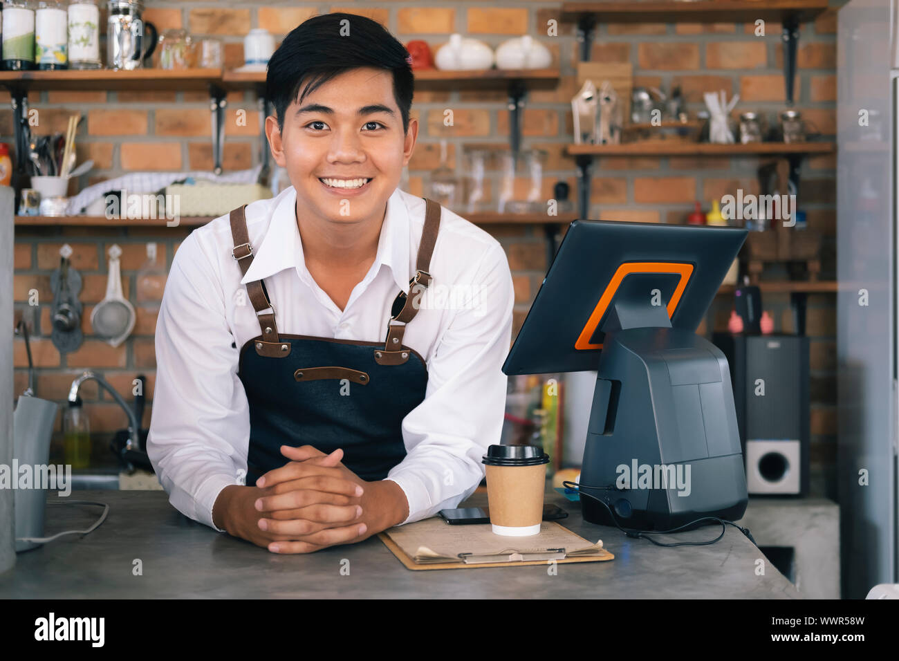 Small business happy owner of a coffee cafe. Young startup owner small cafe shop. Stock Photo