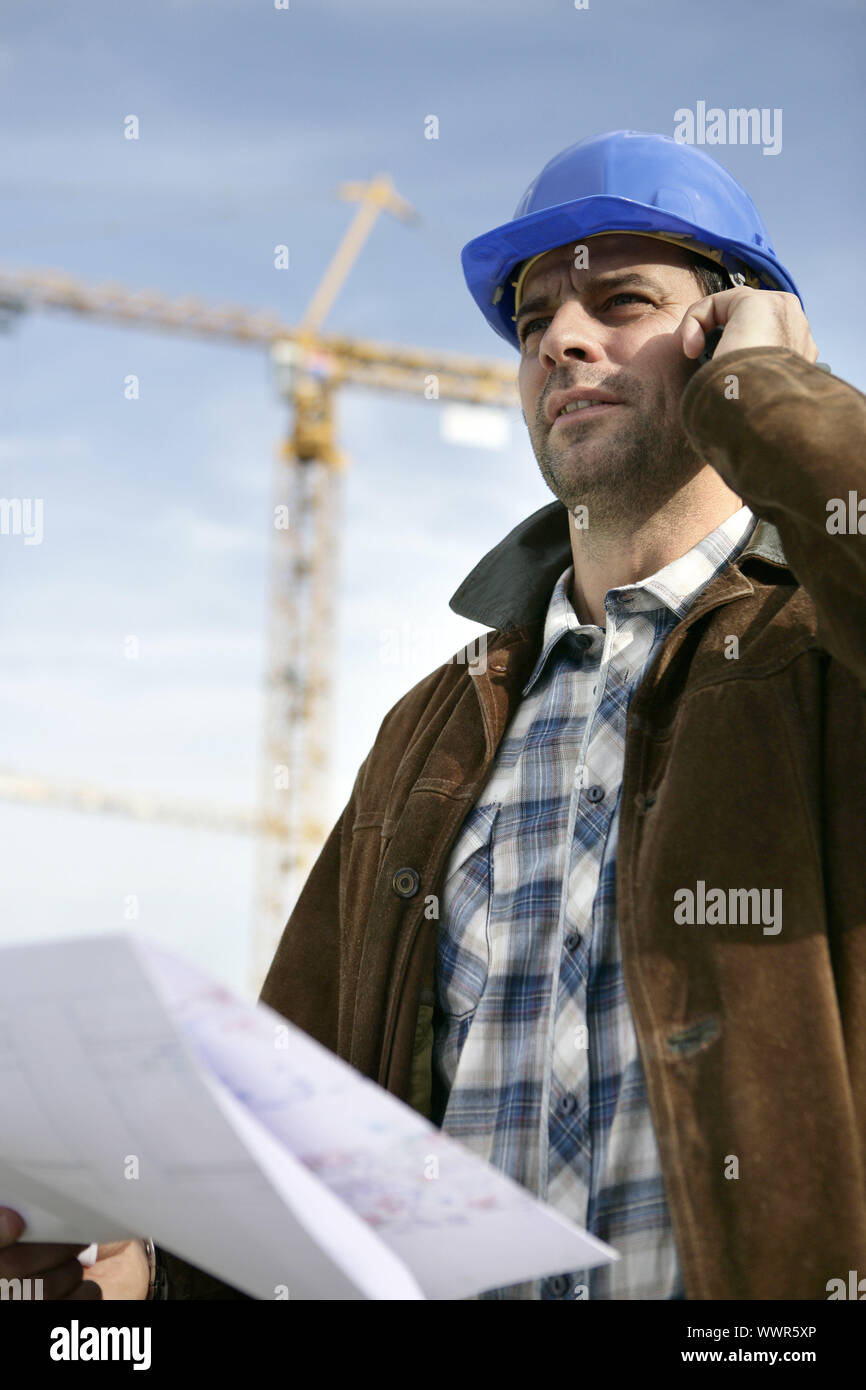 Foreman stood in front of crane Stock Photo