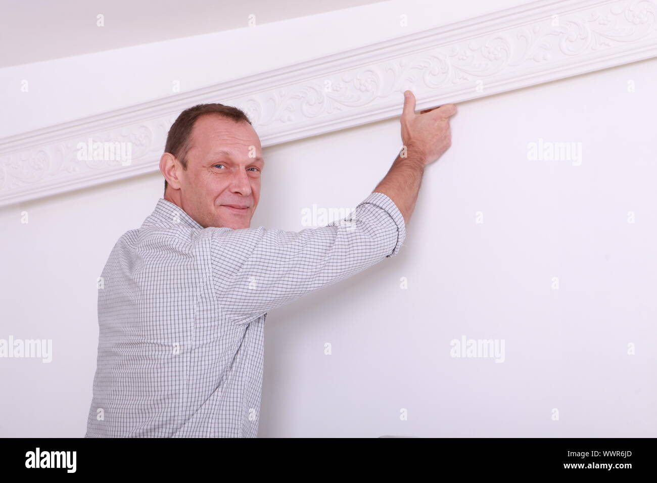 Decorator fixing coving to a ceiling Stock Photo Alamy