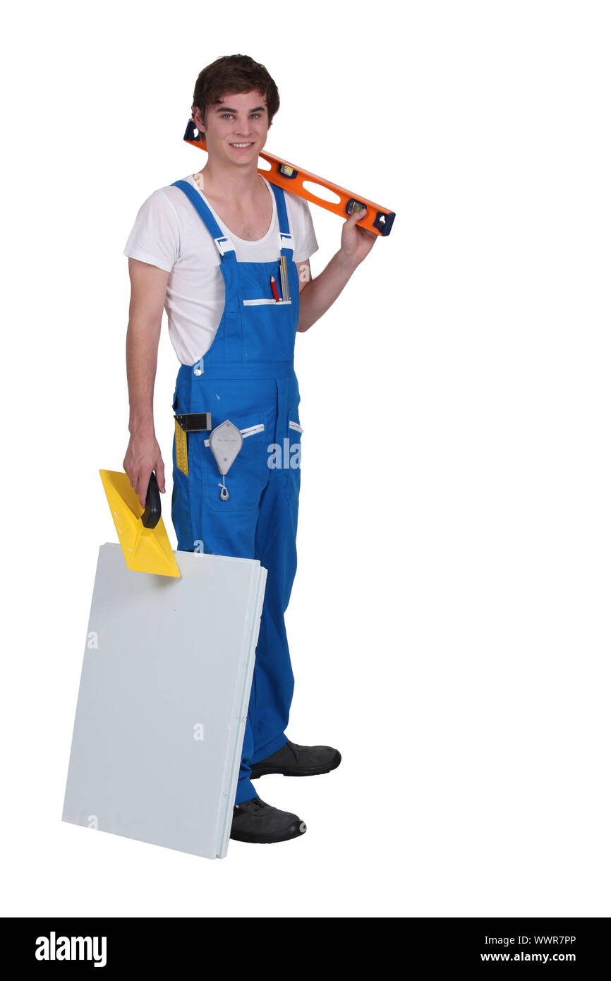 Young tradesman posing with his tools and materials Stock Photo