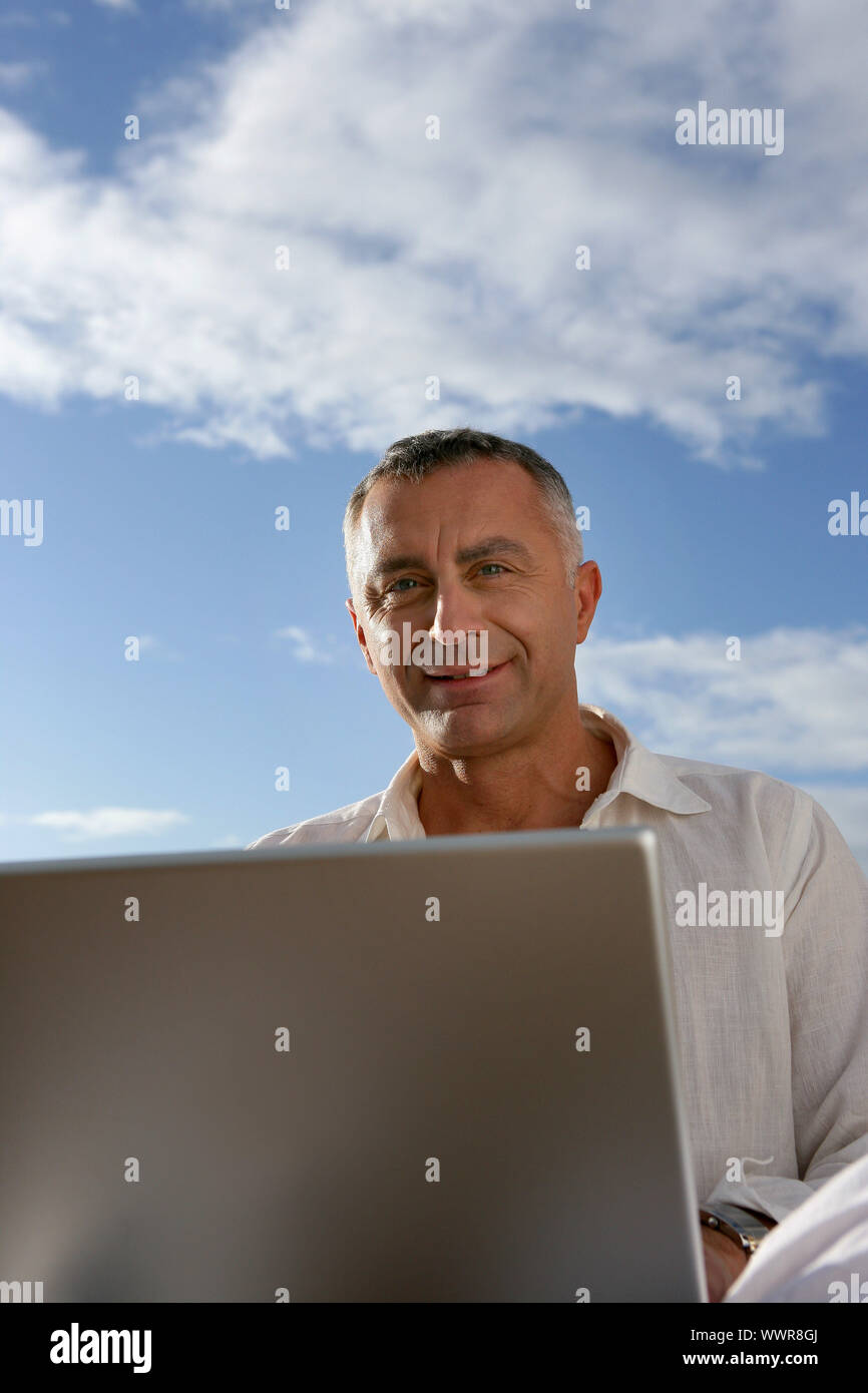mature man working outdoors with laptop Stock Photo