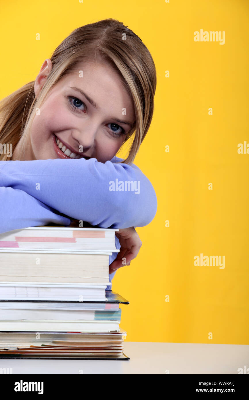 student leaning on a pile of books Stock Photo - Alamy