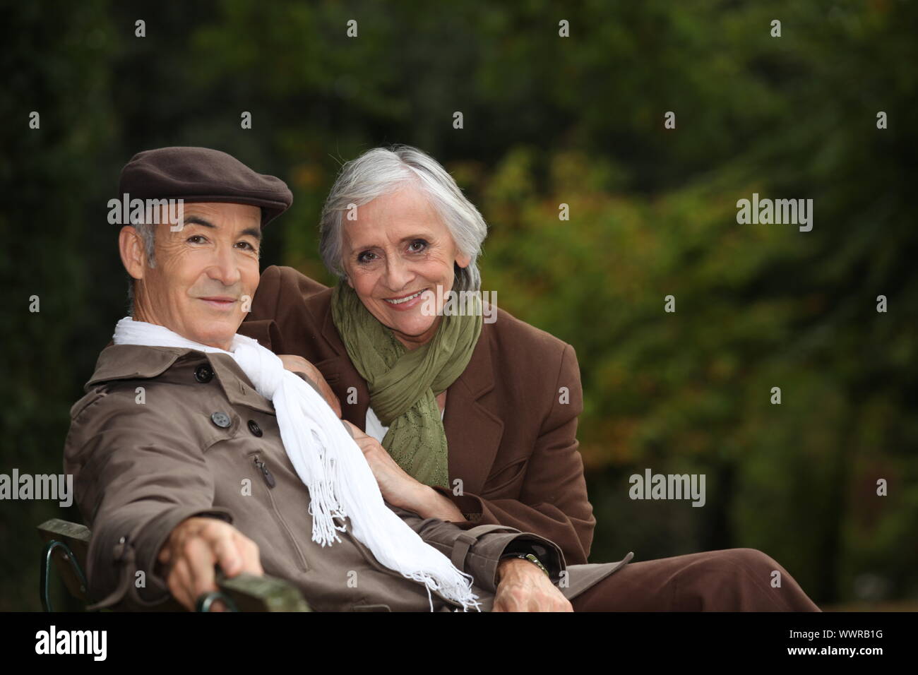 Elegant elderly couple sitting on a park bench Stock Photo - Alamy
