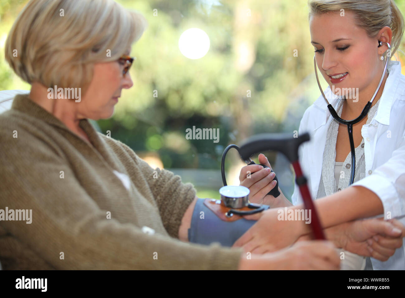 nurse is checking old woman's blood pressure Stock Photo