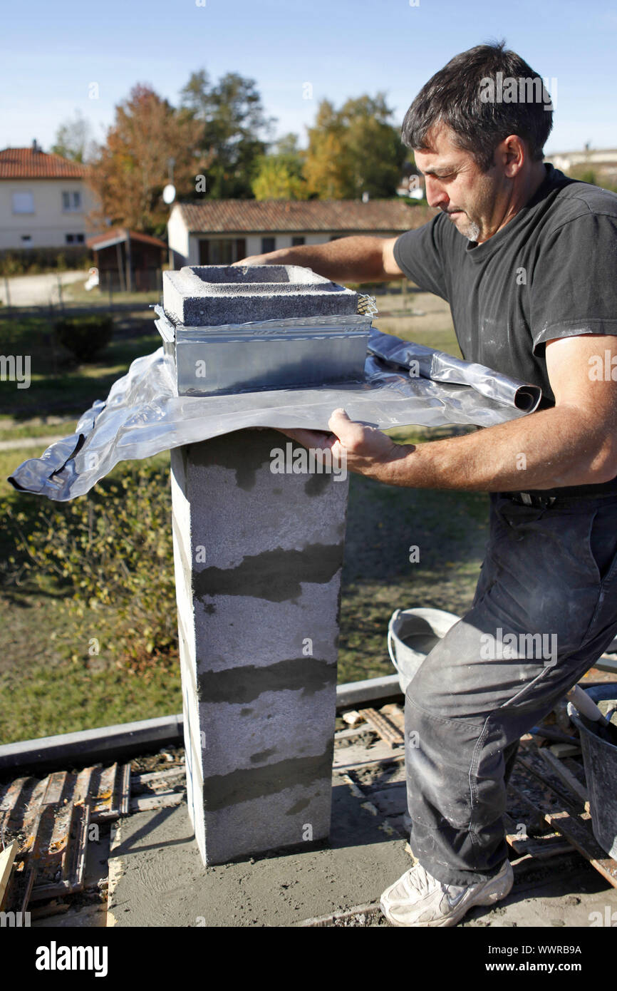 Builder using zinc flashing in the construction of a pillar Stock Photo