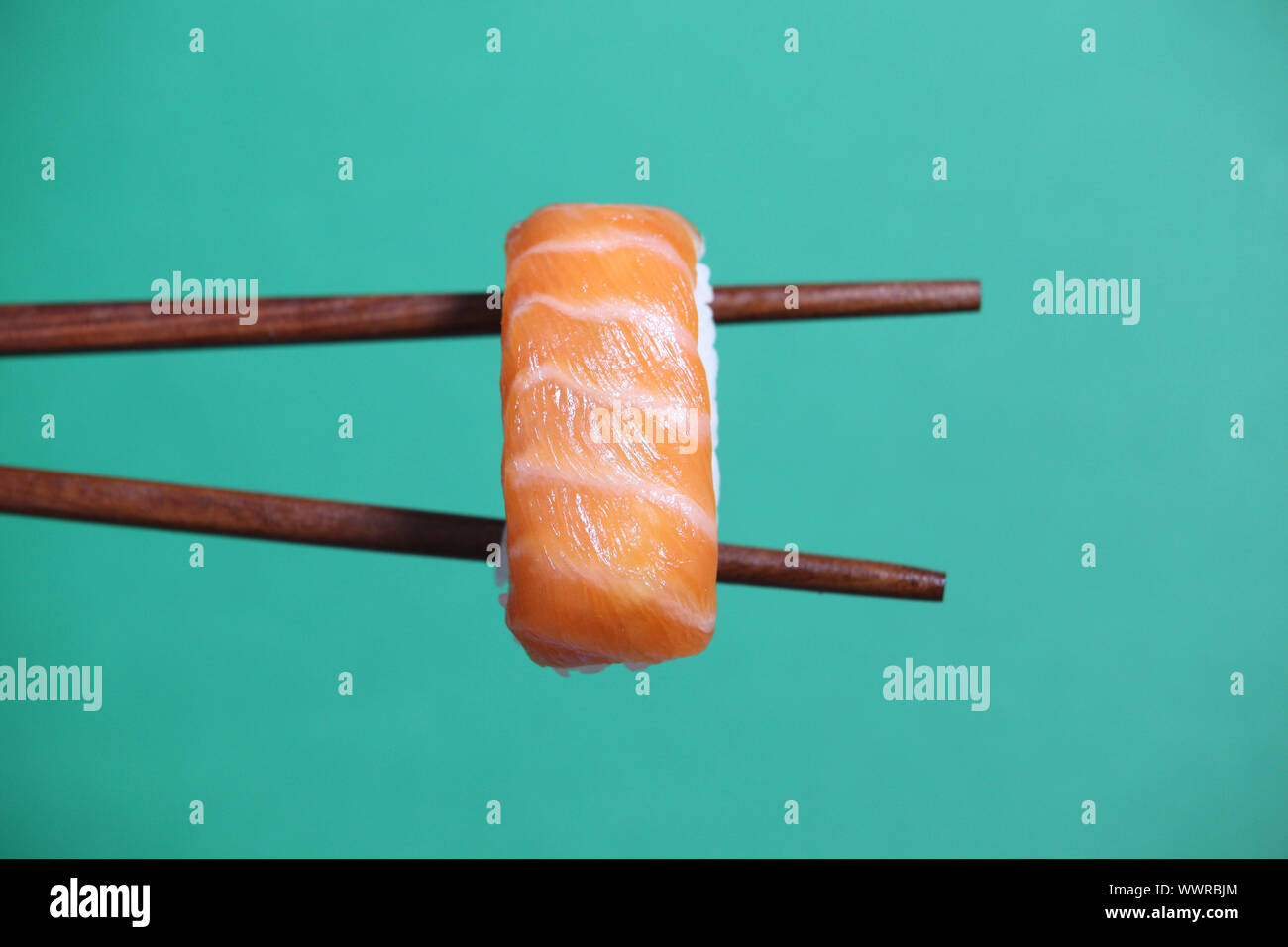 Sushi on chopsticks Stock Photo