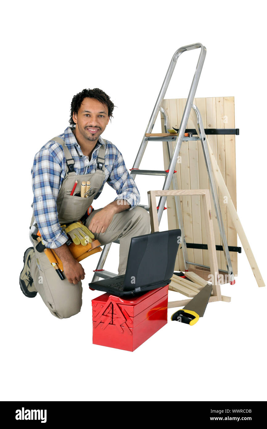 Tradesman posing with his building materials, tools and laptop Stock Photo