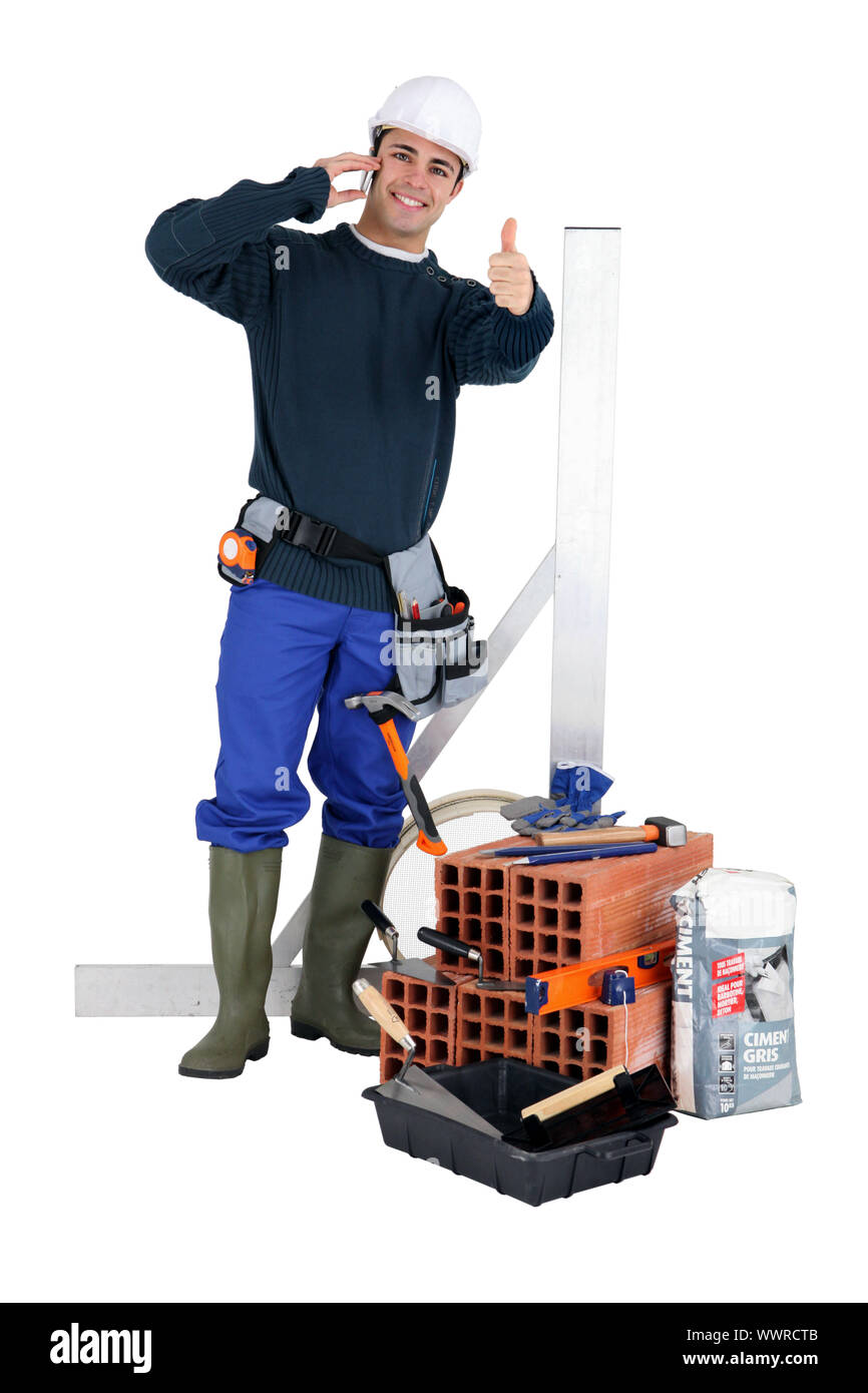 A bricklayer posing with his tools and building materials Stock Photo ...