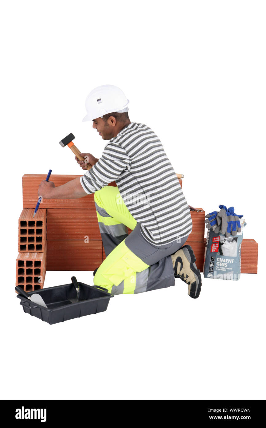 Man chiseling away at aerated brick Stock Photo Alamy