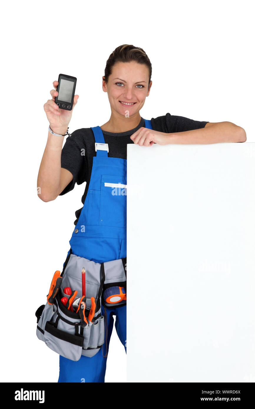 Woman with blank board, toolbelt and cellphone Stock Photo