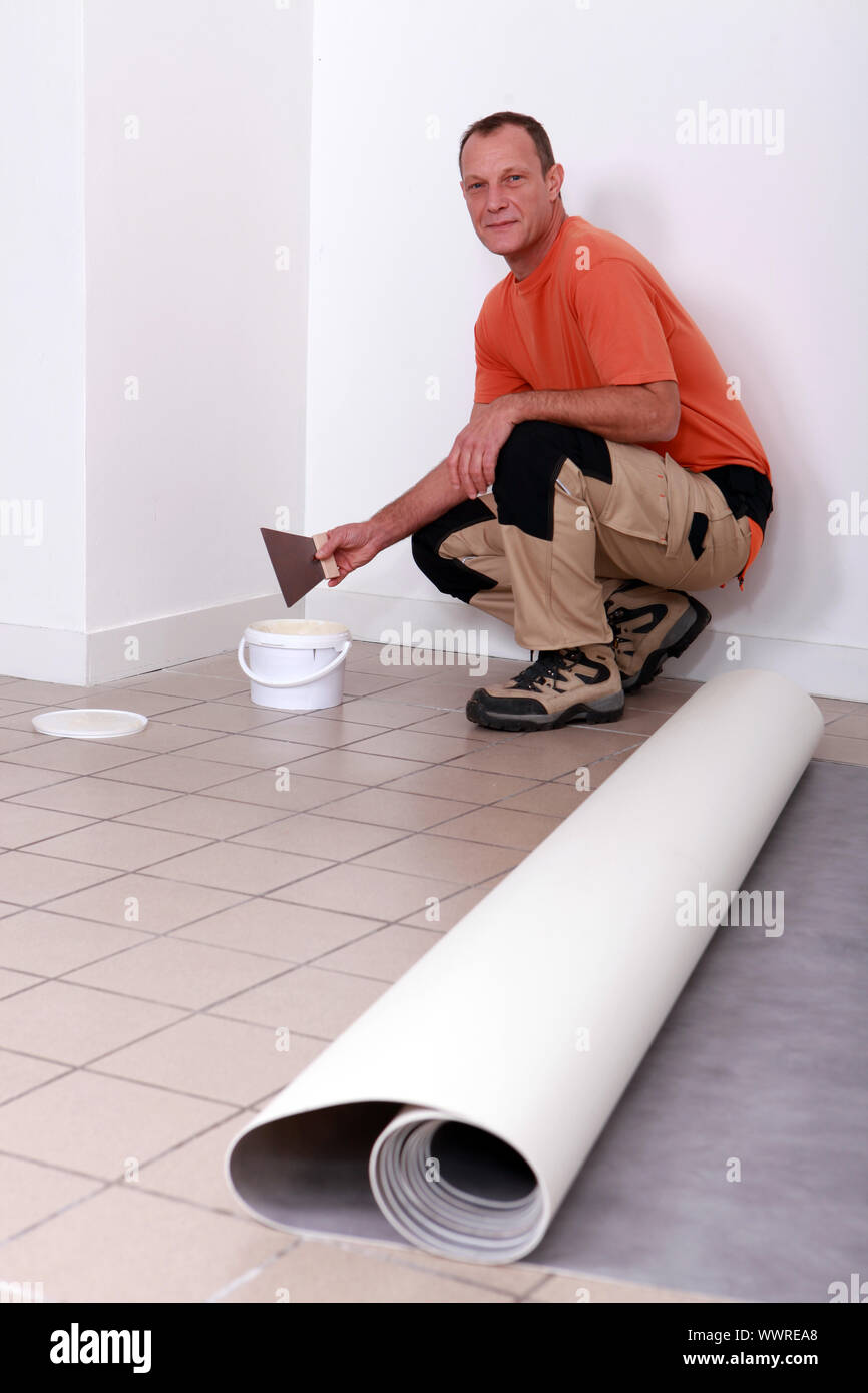 Laborer crouching in kitchen Stock Photo