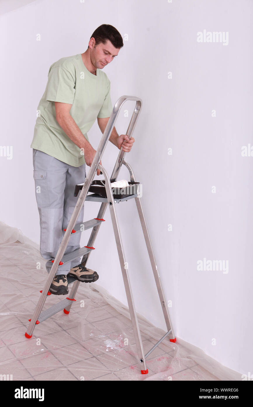 Man painting on a ladder Stock Photo