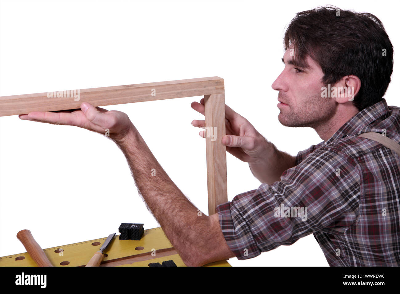 Joiner inspecting wooden frame Stock Photo