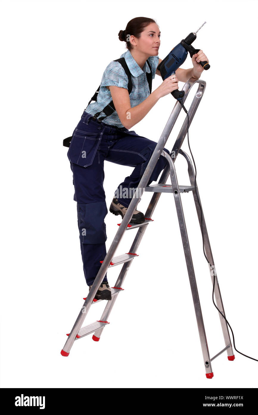 Woman with drill climbing ladder Stock Photo Alamy