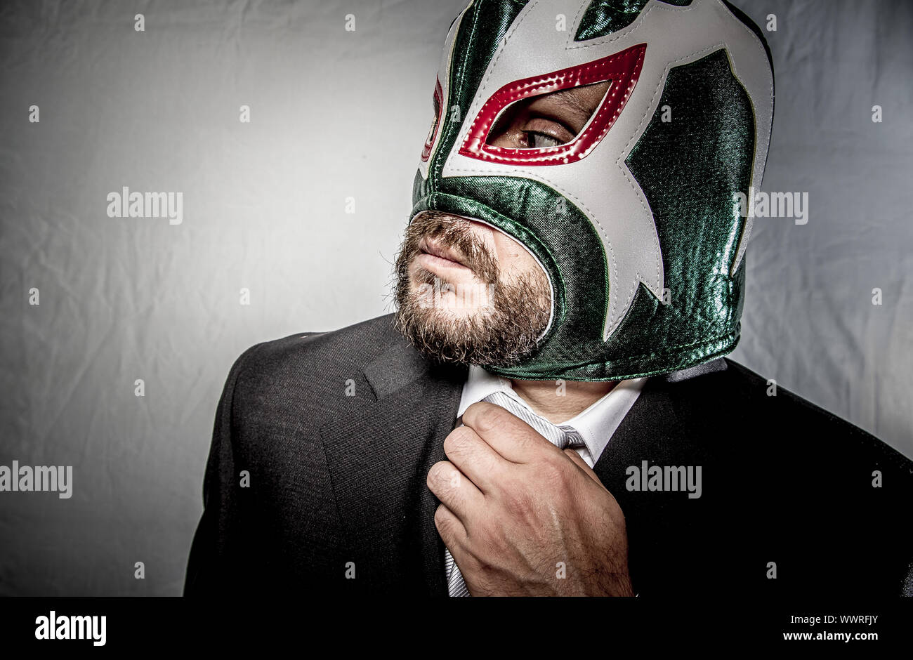 Work, Angry businessman with mask of Mexican fighter, dressed in suit and tie Stock Photo