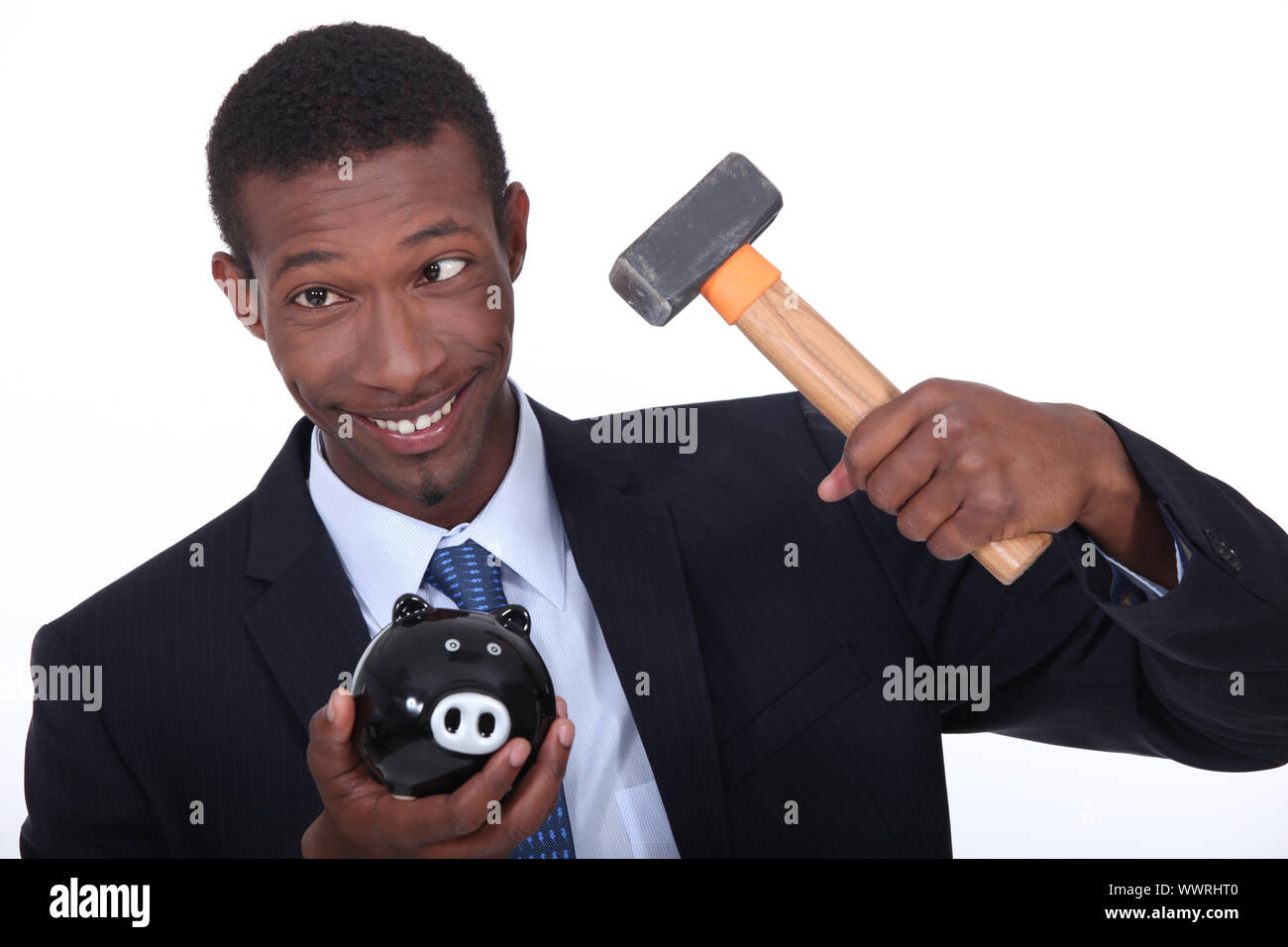 Man trying to break into a piggy bank with a hammer Stock Photo - Alamy