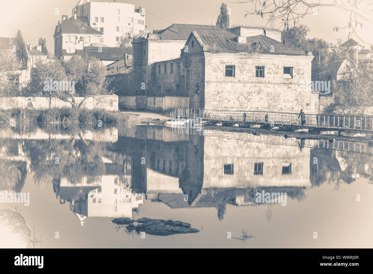 Old vintage photo. Old brick building, river with smooth surface. Mirror reflection. Urban landscape. City landscape Stock Photo