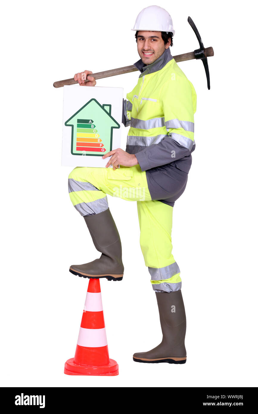 Construction worker holding a pickaxe and an energy efficiency rating sign Stock Photo