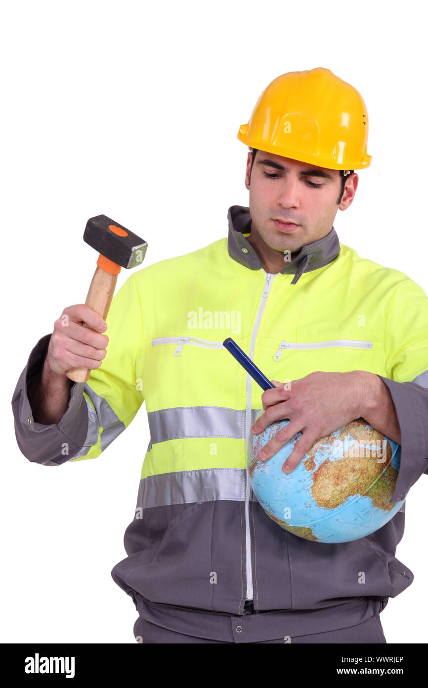 Man using hammer and chisel on globe Stock Photo