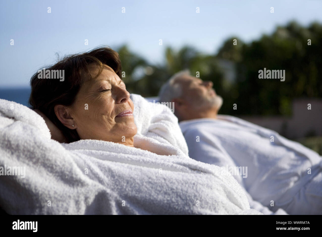 Couple laying outside in bathing robes Stock Photo