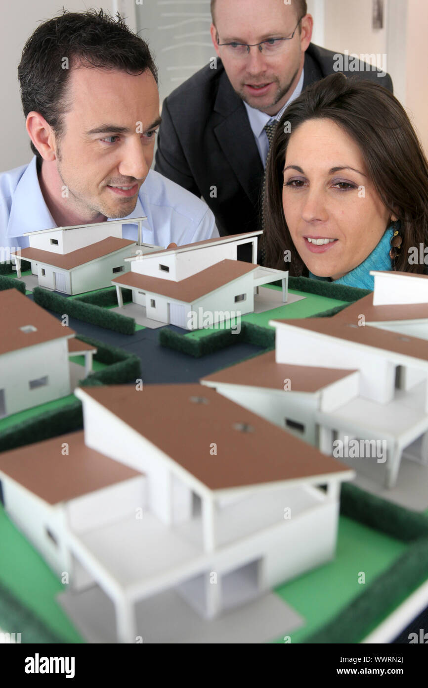 Architect showing scale model of house to buyers Stock Photo Alamy