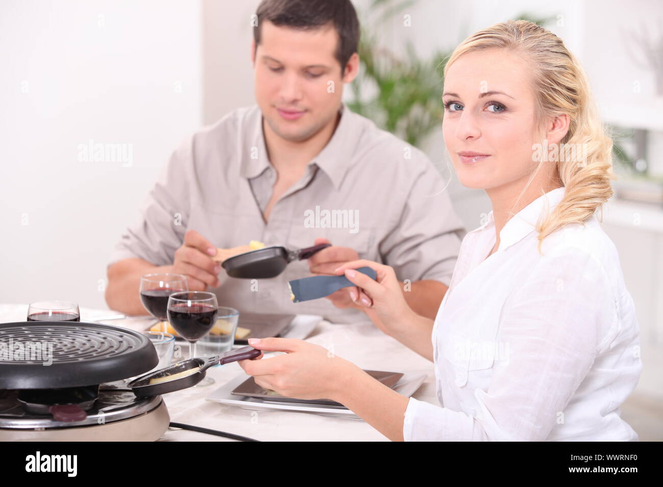 Couple eating raclette Stock Photo - Alamy