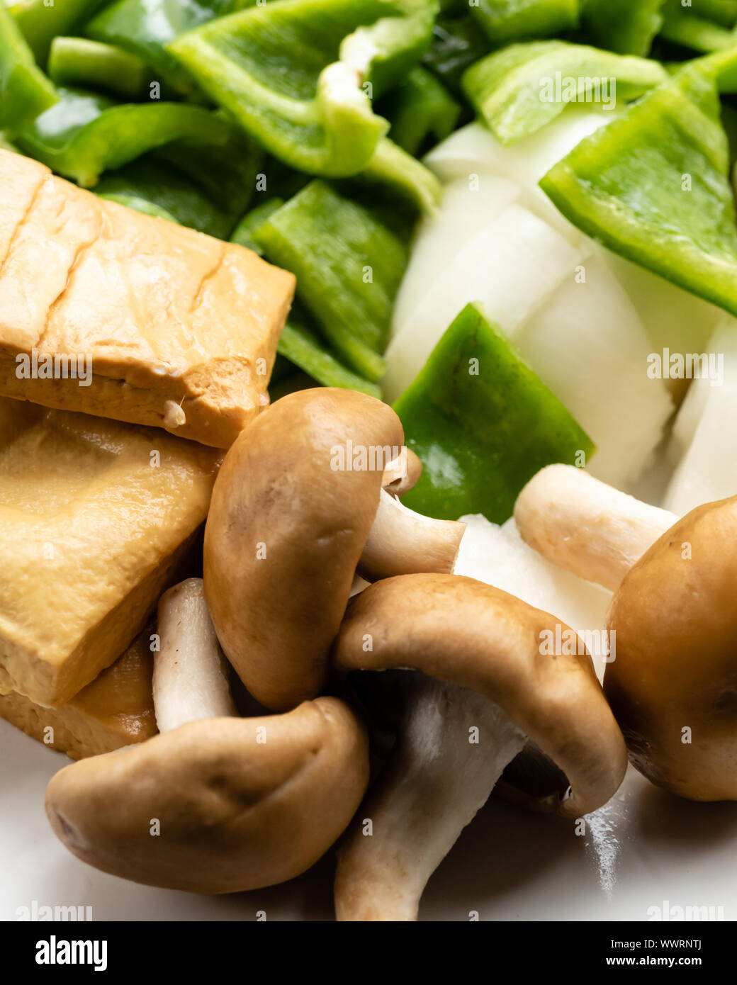 Green peppers, tofu, onion, and mushrooms in plate Stock Photo