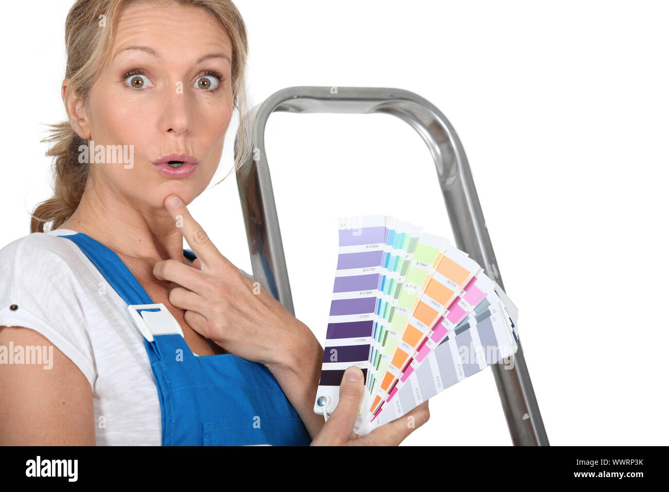 Blond woman choosing paint colour Stock Photo
