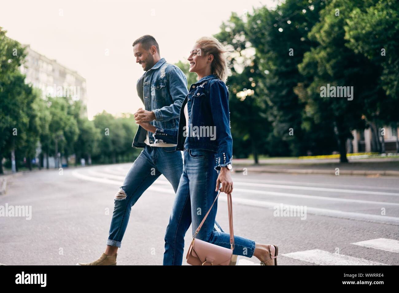 Young happy couple running crosswalk in the street. Fun, walking, dating concept Stock Photo