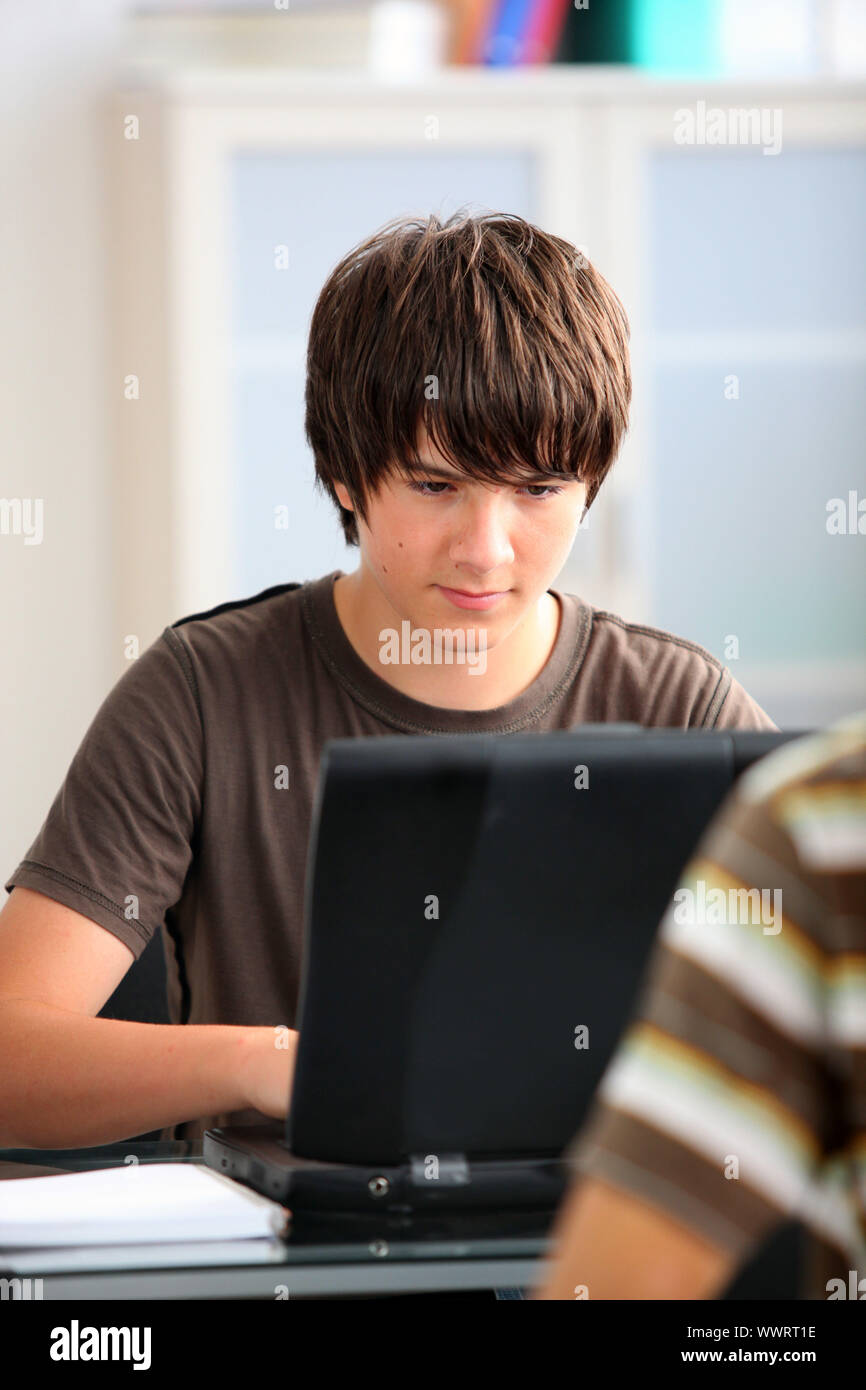 Adolescent boy working on his laptop Stock Photo - Alamy