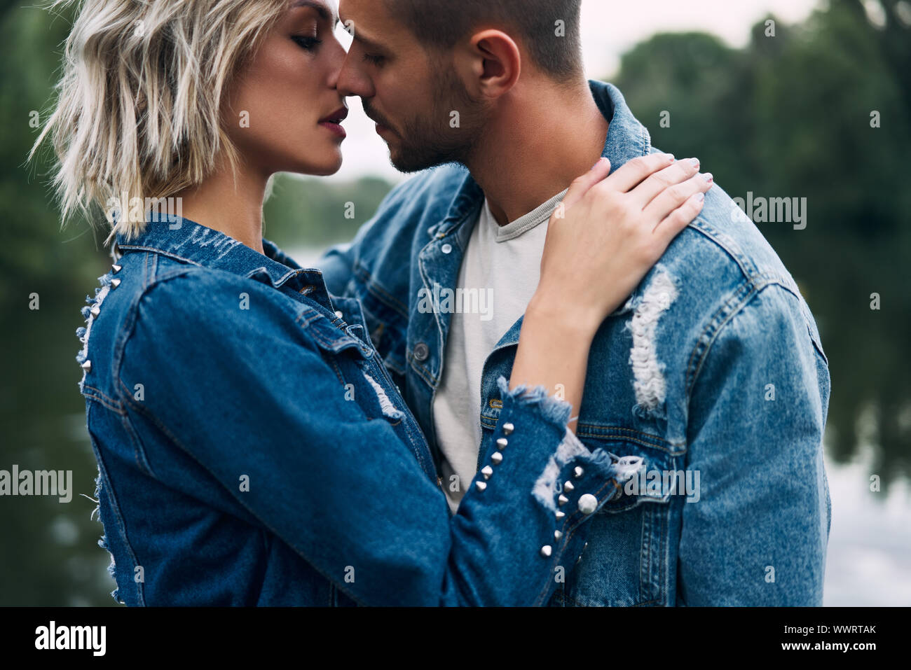 Young loving couple kissing and enjoying the company of each other outdoors. Love, passion, dating concept Stock Photo