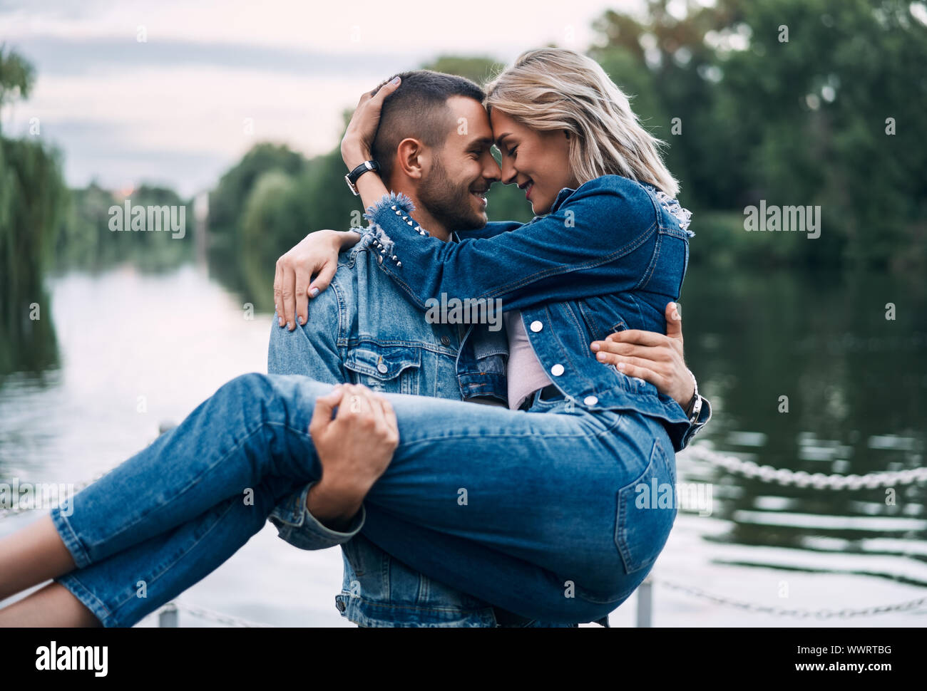 Man holding woman on hands. Happy couple enjoy each other on nature. Tenderness, trust, love concept Stock Photo
