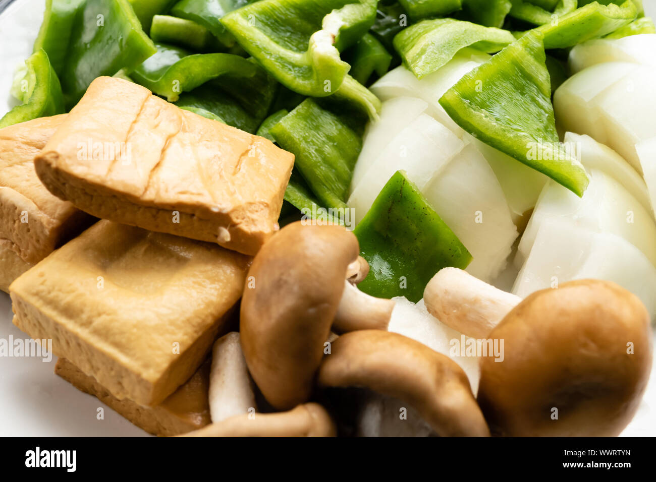 Green peppers, tofu, onion, and mushrooms in plate Stock Photo