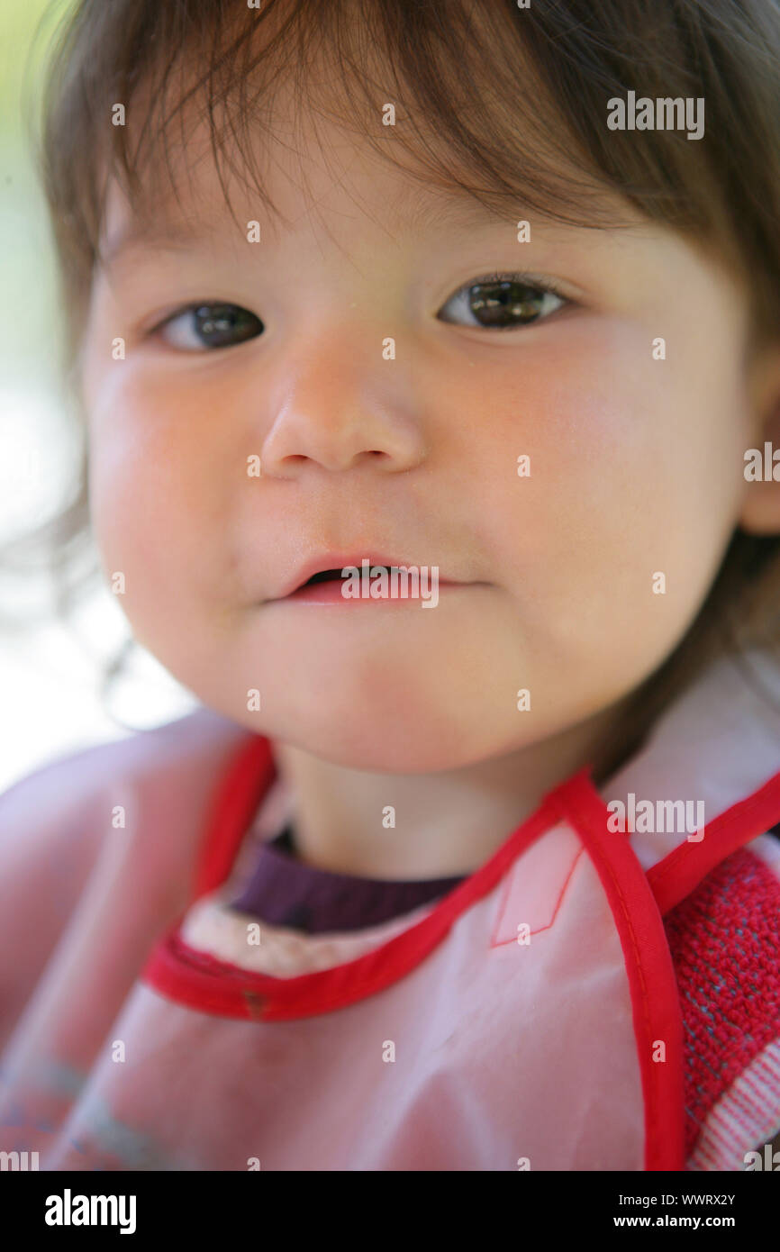 Little girl wearing a bib Stock Photo