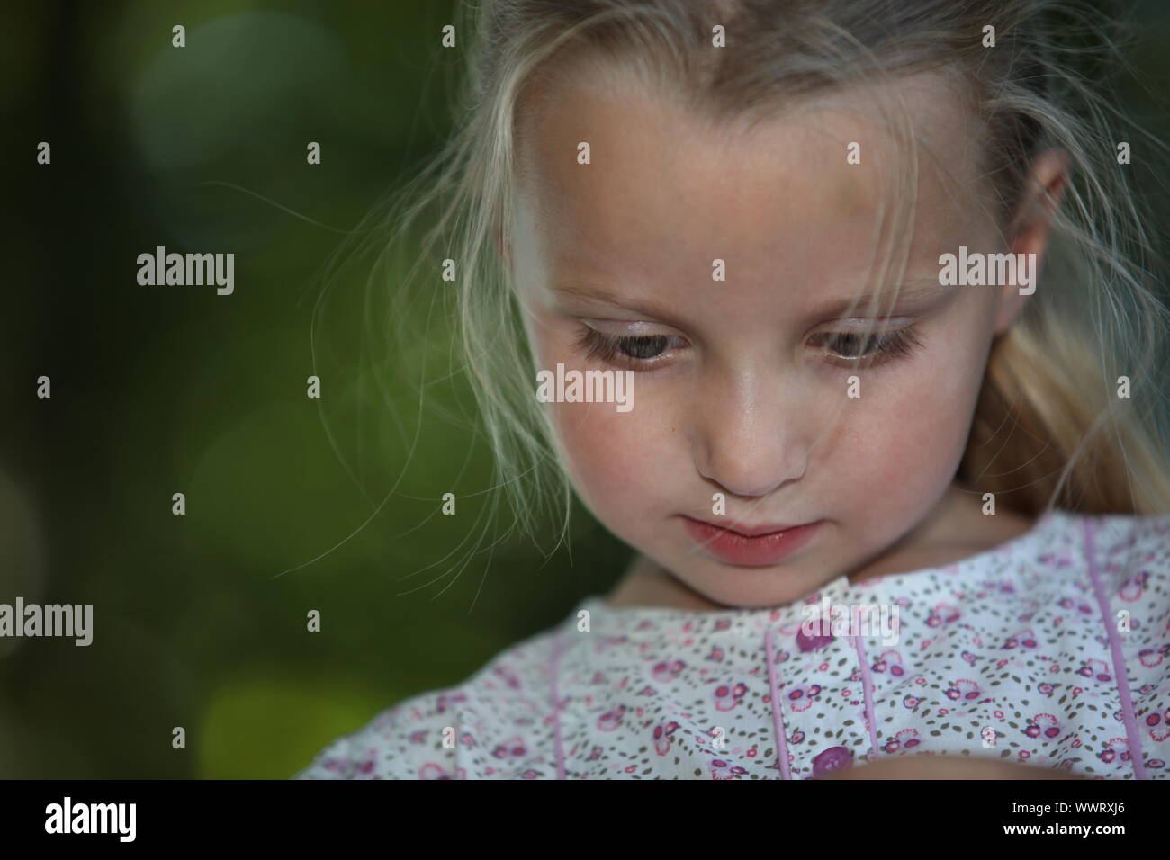 close shot of fair-haired schoolgirl with downcast eyes Stock Photo
