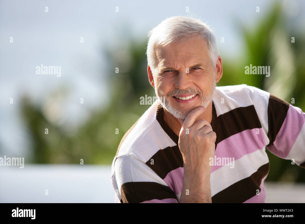 Elderly man sitting in garden Stock Photo