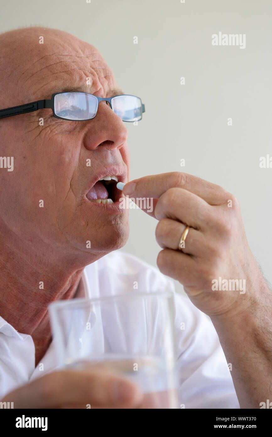 Elderly man swallowing a pill Stock Photo Alamy