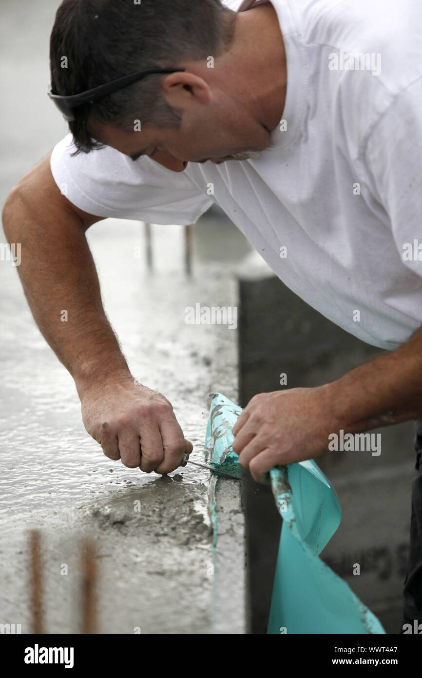 Mason removing plastic sheet from wall Stock Photo Alamy