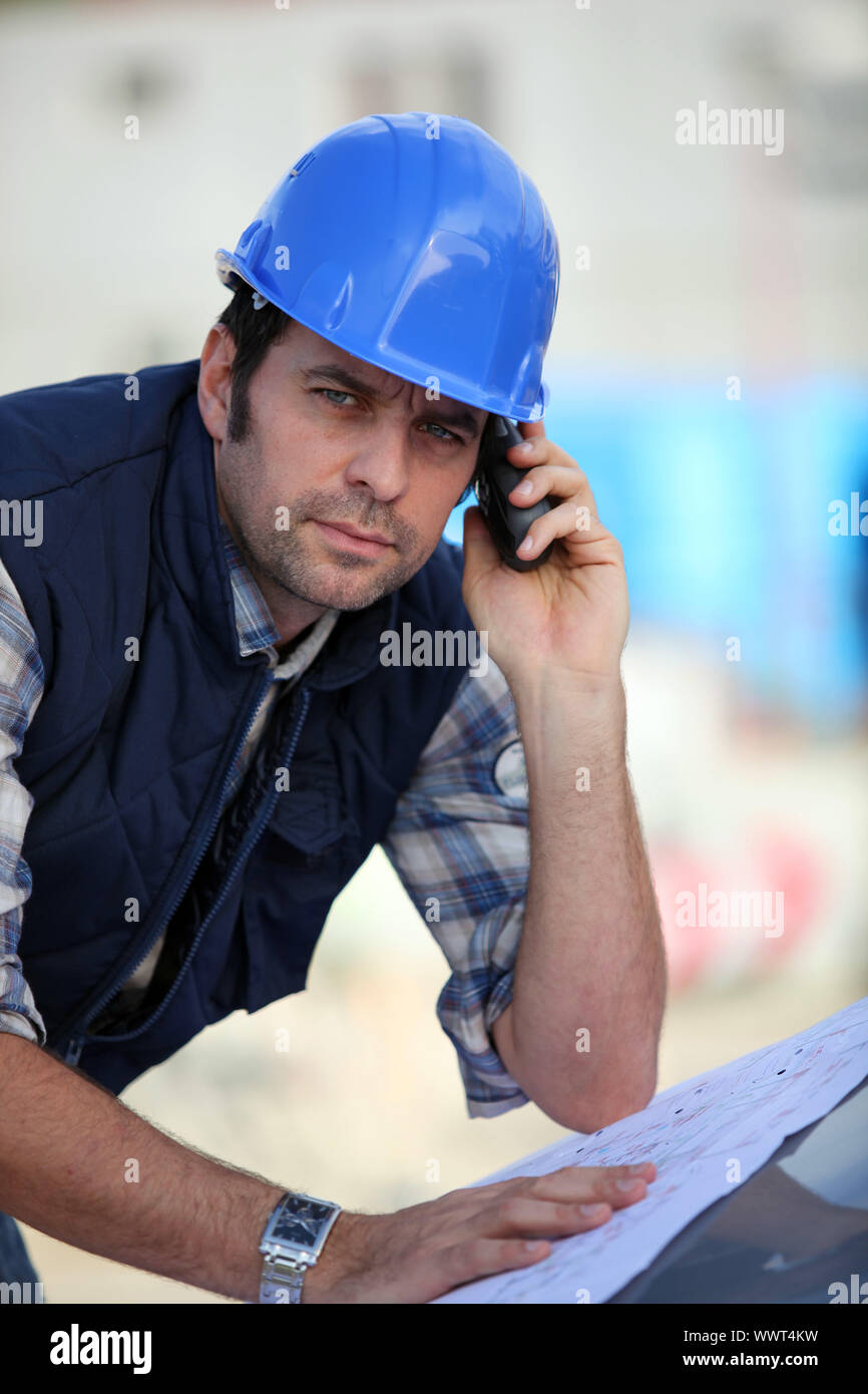 Foreman  checking plans whilst on the phone Stock Photo