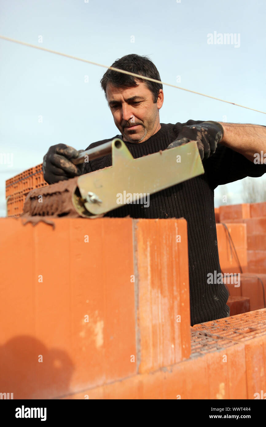 Mason using special device to pour cement evenly Stock Photo