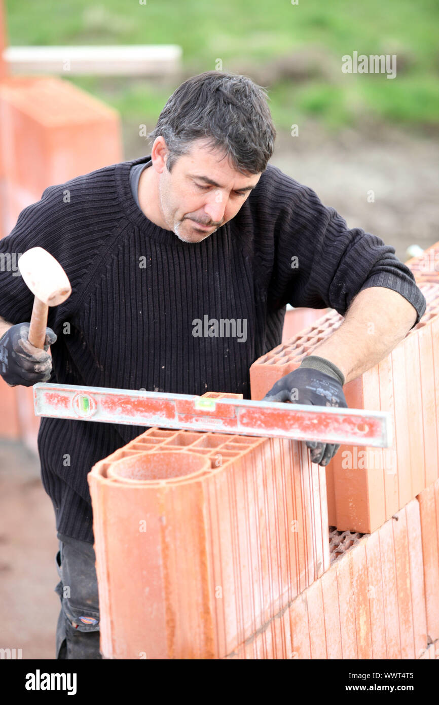 Builder using a spirit level Stock Photo - Alamy