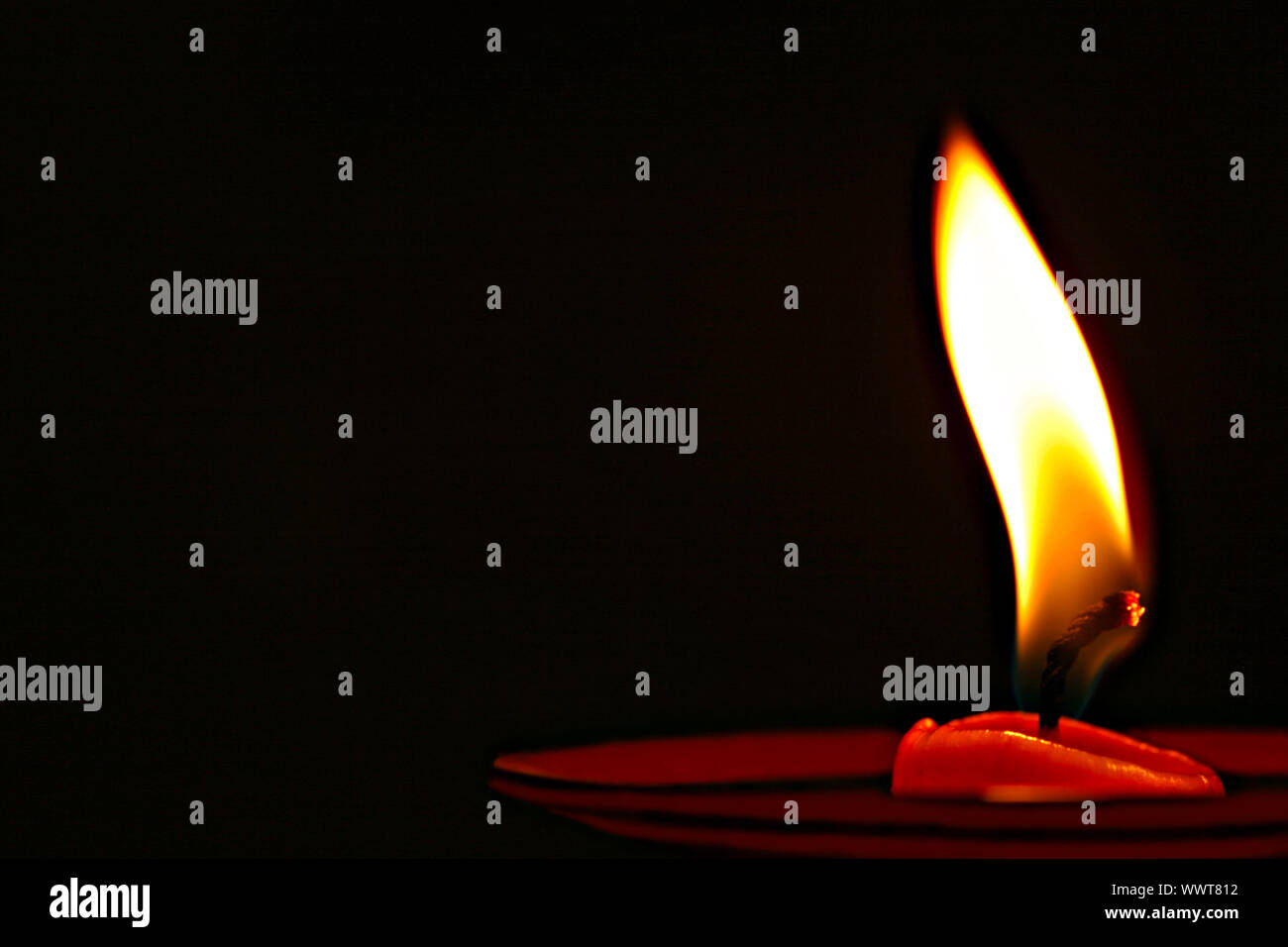 Beautiful burning candle isolated on black background Stock Photo - Alamy