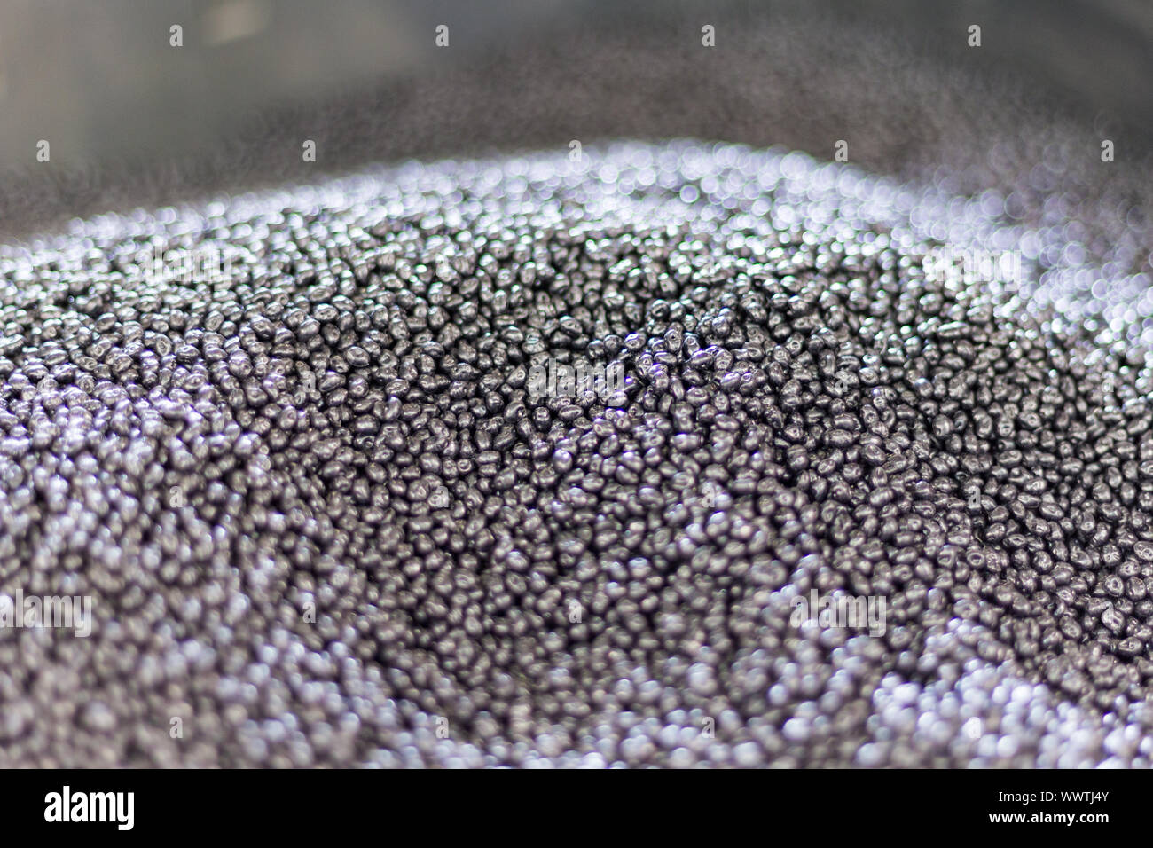 Heap of small grains of unprocessed plastic granules in a factory Stock Photo
